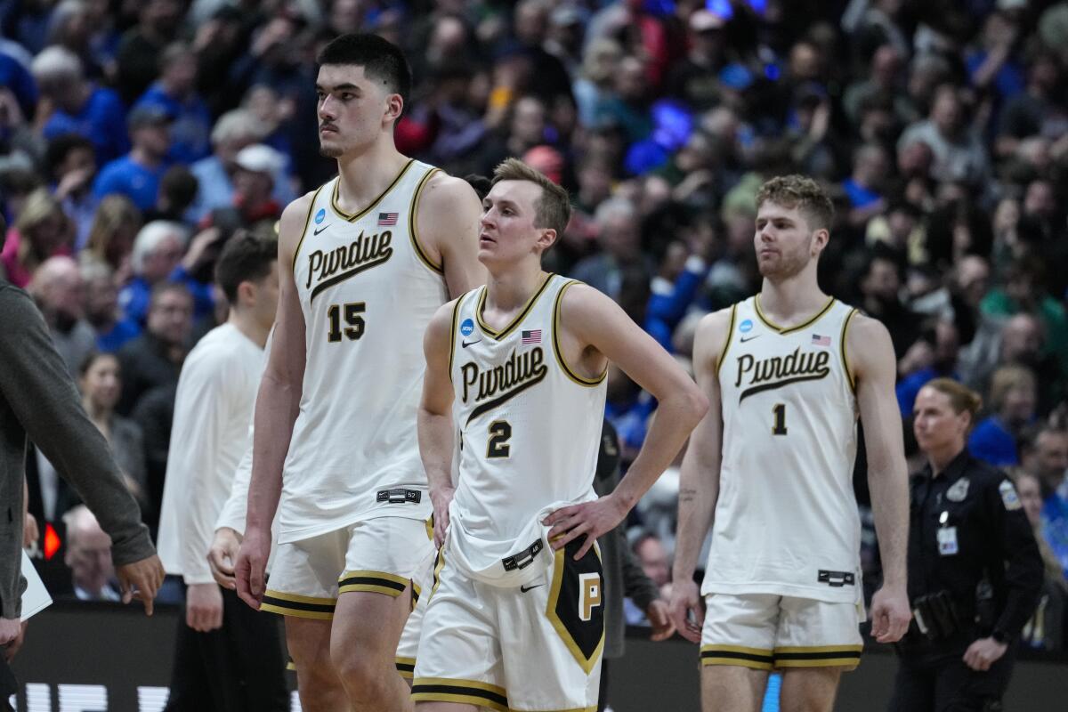 Purdue's Zach Edey (15), Fletcher Loyer (2) and Caleb Furst (1) walk off the court after losing to Fairleigh Dickinson. 