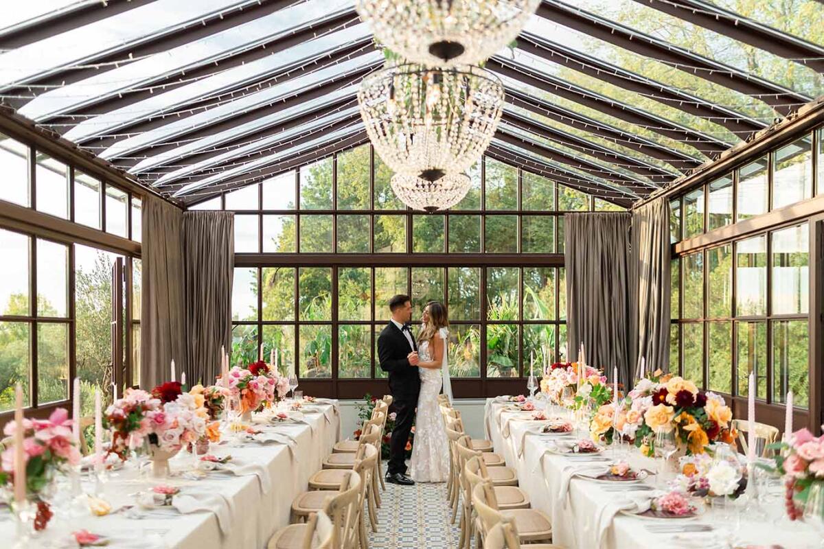 A bride and groom pose in the greenhouse at San Canzian.