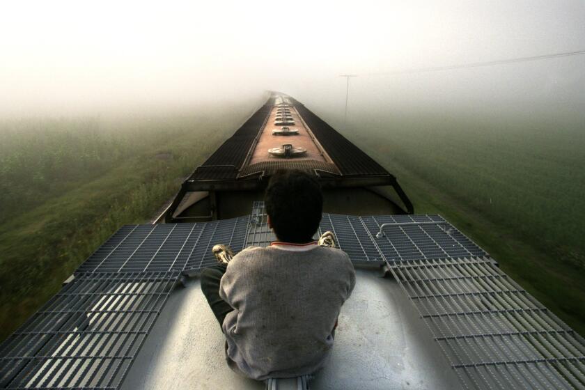 Don Bartletti –– – A lone Central American youth rides atop a freight train as it heads into a fog bank near Teotihuacan, Mexico. Next stop, Lecheria, on the outskirts of Mexico City. This is a major migratory transportation route for undocumented Central Americans struggling to reach the U.S. border.