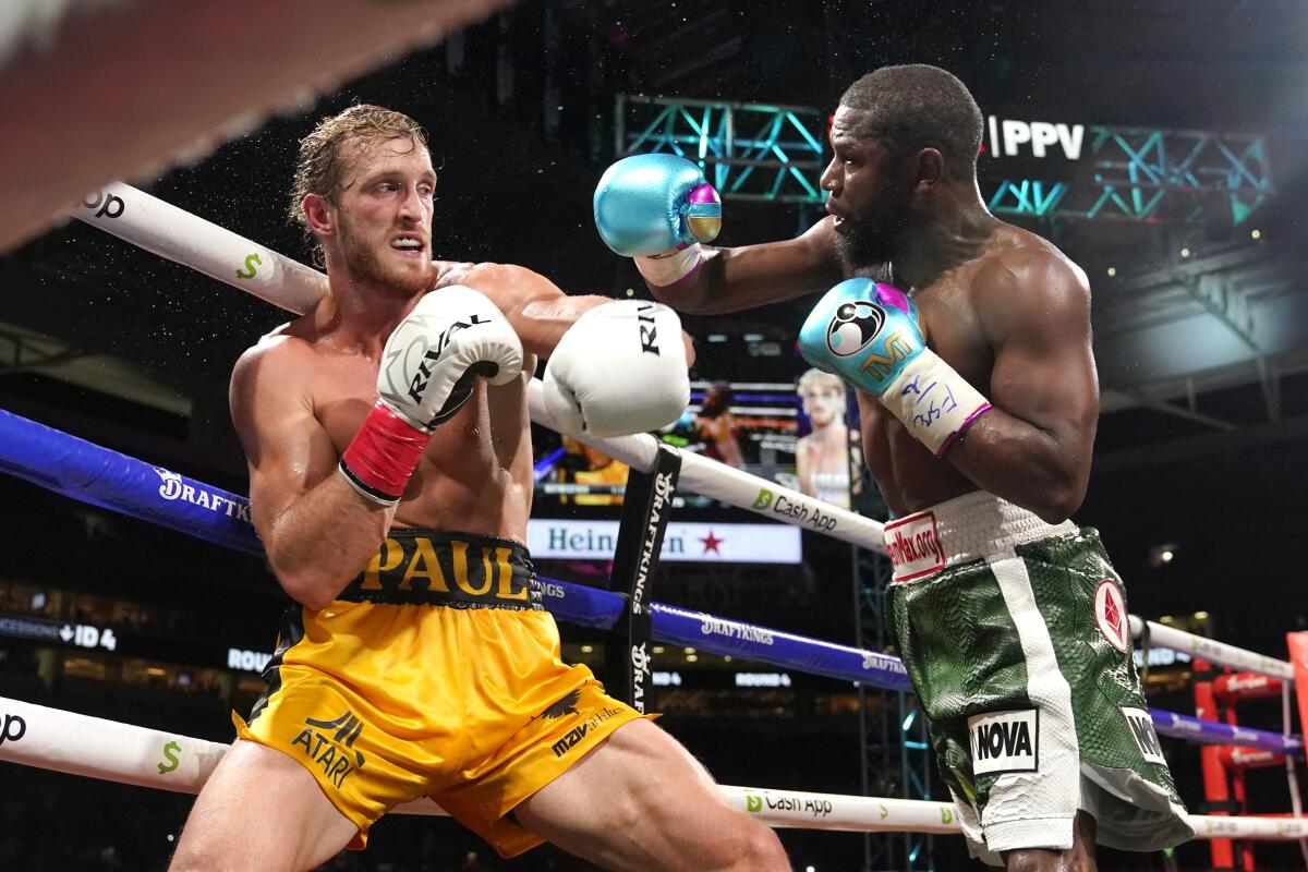 Logan Paul and Floyd Mayweather Jr. fight during an exhibition boxing match.