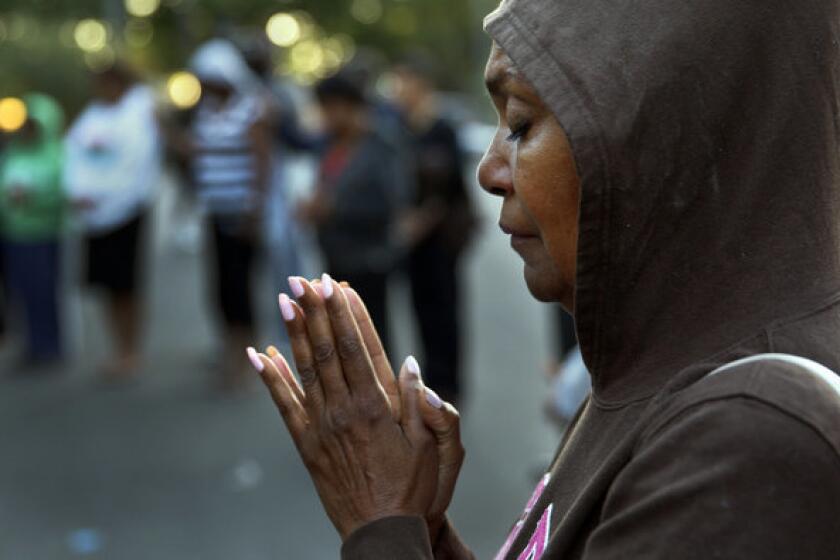 Alicia Dhanifu, of Pasadena, prays during a peaceful march protesting George Zimmerman's acquittal earlier this week. Police throughout the region were on alert Friday for any protest that might get out of hand.