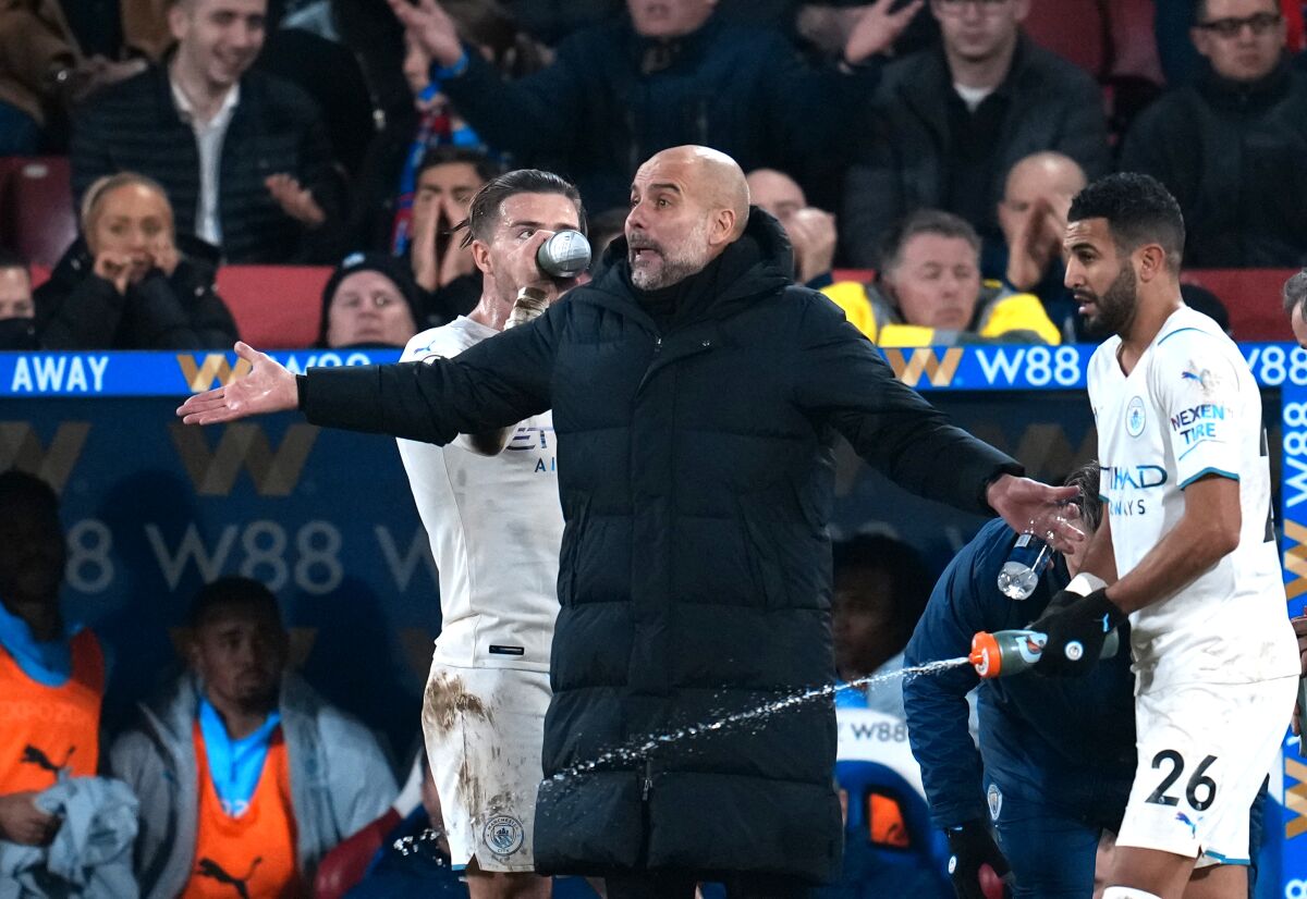 Manchester City's head coach Pep Guardiola, center, reacts during the English Premier League soccer match between Crystal Palace and Manchester City at Selhurst Park stadium in London, Monday, March 14, 2022. (AP Photo/Matt Dunham)