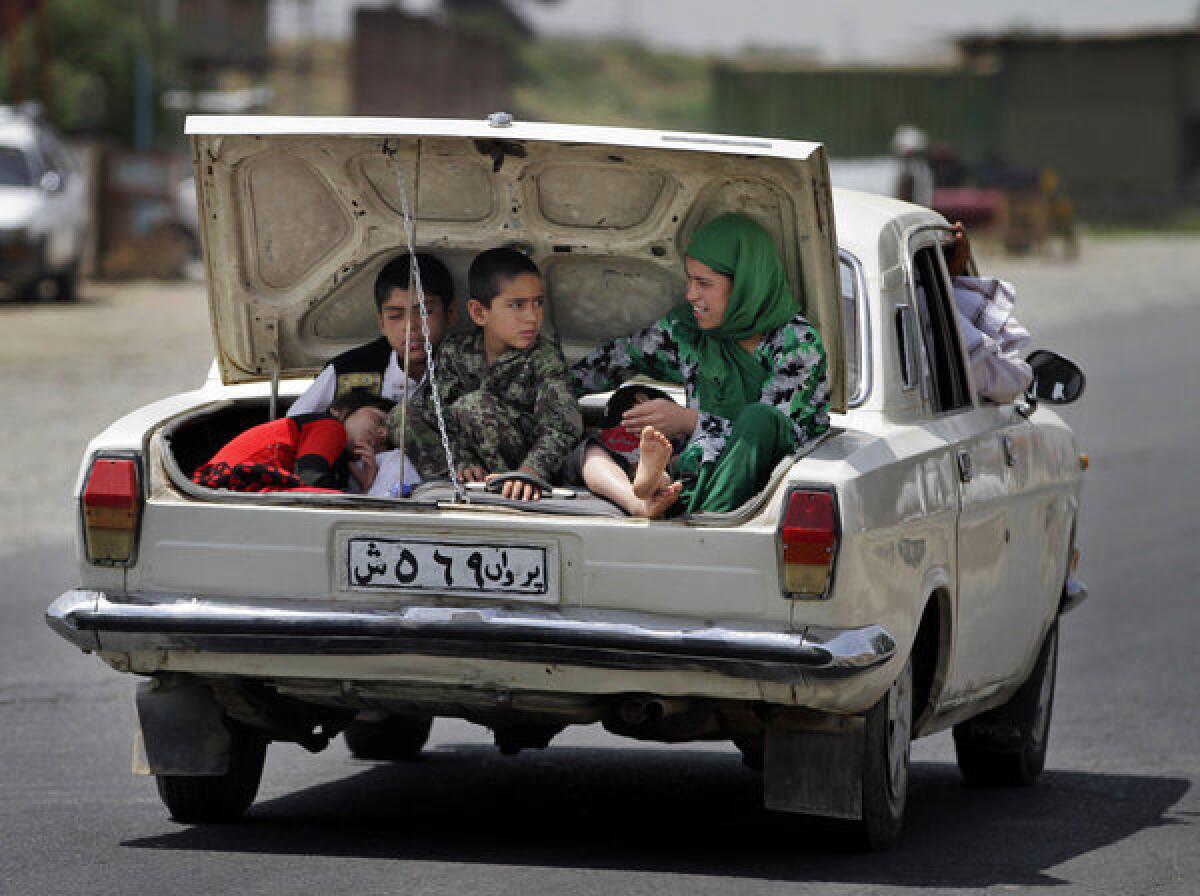 Afghan children ride in the trunk of a car on the outskirts of the capital, Kabul.