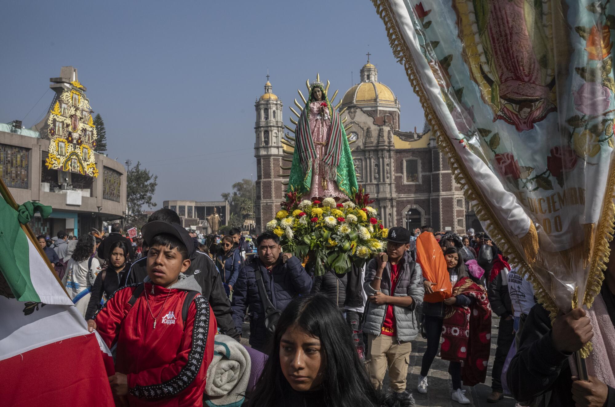 Pilgrims carrying a clay figure of the Virgin walk out from the Basilica of Guadalupe on Dec. 12, 2023, in Mexico City