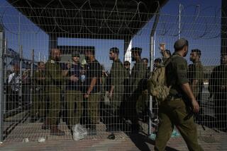 Israeli soldiers gather at the gate to the Sde Teiman military base, where inside, soldiers are being questioned for detainee abuse, Monday, July 29, 2024. The Israeli military said Monday it was holding nine soldiers for questioning following allegations of "substantial abuse" of a detainee at a shadowy facility where Israel has held Palestinian prisoners throughout the war in Gaza. (AP Photo/Tsafrir Abayov)