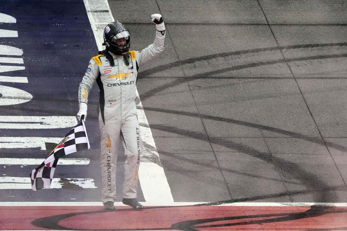 Kyle Busch celebrates with the checkered flag on the track after winning Sunday.
