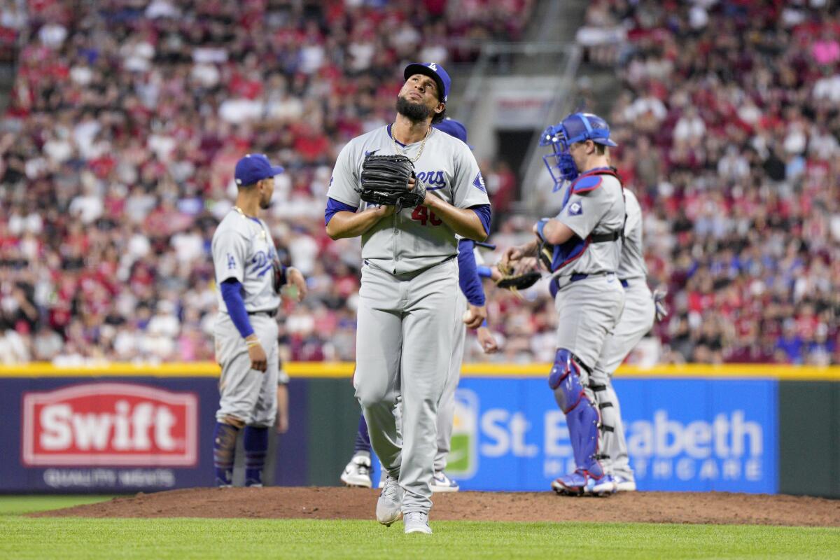 Dodgers reliever Yohan Ramírez walks to the dugout after being pulled in the fifth inning against the Reds.