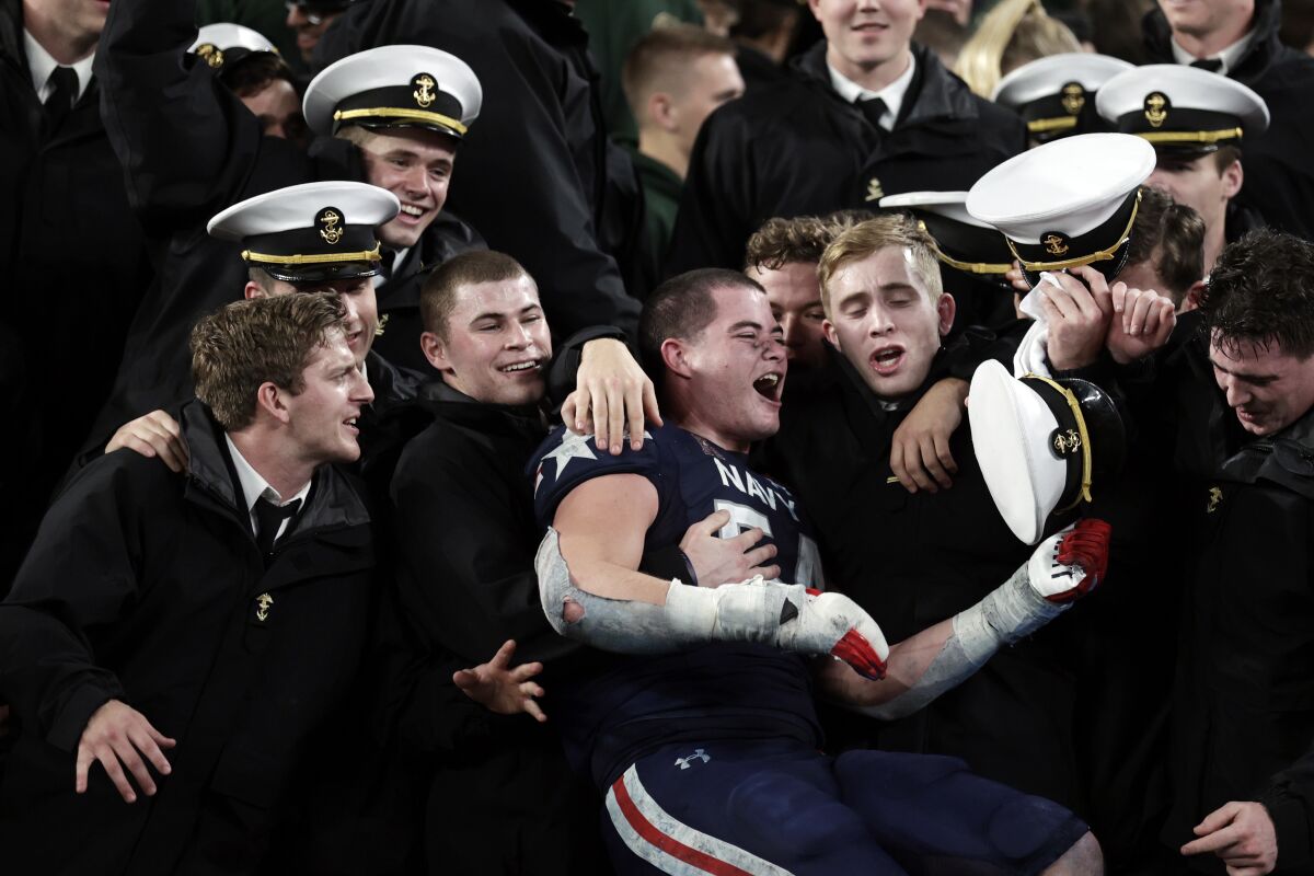 Navy linebacker Diego Fagot (54) celebrates with his fellow midshipmen after the win over Army on Dec. 11, 2021.