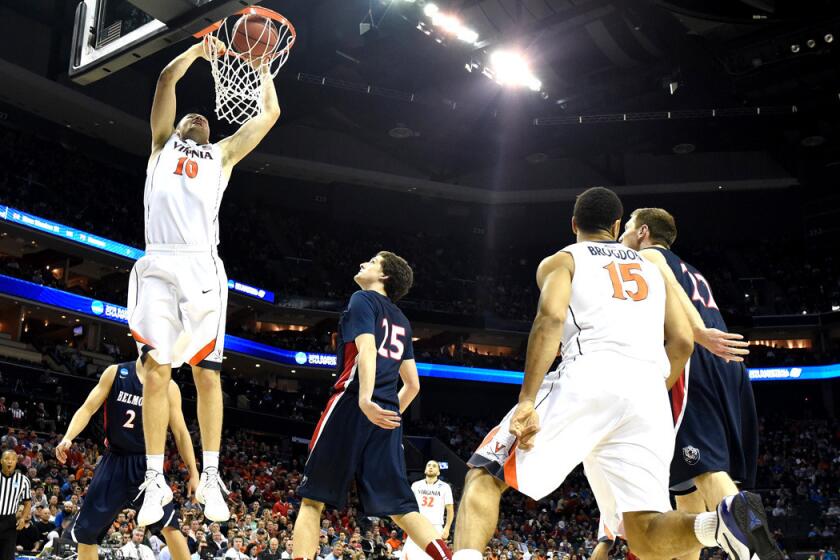 Virginia's Mike Tobey dunks over Belmont players during the second round of the 2015 NCAA Men's Basketball Tournament on Friday.