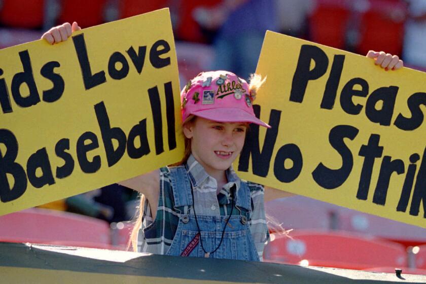 Erin States, 10, of Tracy, Calif., holds up a sign at an Oakland A's game on Aug. 11, 1994, urging major leaguers not to strike.