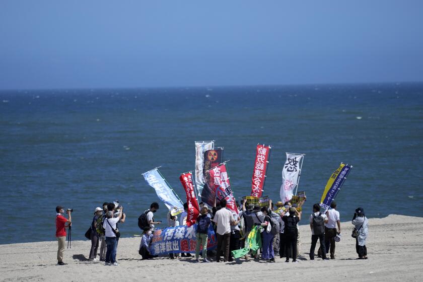 People protest at a beach toward the Fukushima Daiichi nuclear power plant, damaged by a massive March 11, 2011, earthquake and tsunami, in Namie town, northeastern Japan, Thursday, Aug. 24, 2023. The operator of the tsunami-wrecked Fukushima Daiichi nuclear power plant says it began releasing its first batch of treated radioactive water into the Pacific Ocean on Thursday — a controversial step, but a milestone for Japan's battle with the growing radioactive water stockpile. (AP Photo/Eugene Hoshiko)