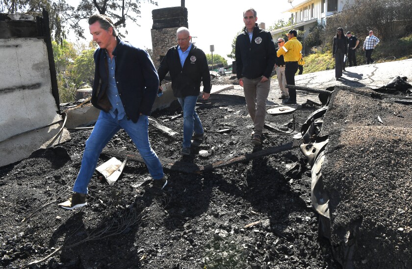From left, California Governor Gavin Newsom, L.A. City Councilman Mike Bonin, and L.A. City Mayor Eric Garcetti tour one of twelve destroyed homes in Brentwood caused by the Getty Fire.