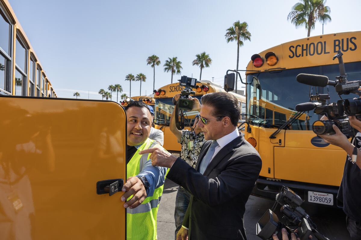 A bus driver trainer opens a panel on an electric bus as part of a tour.