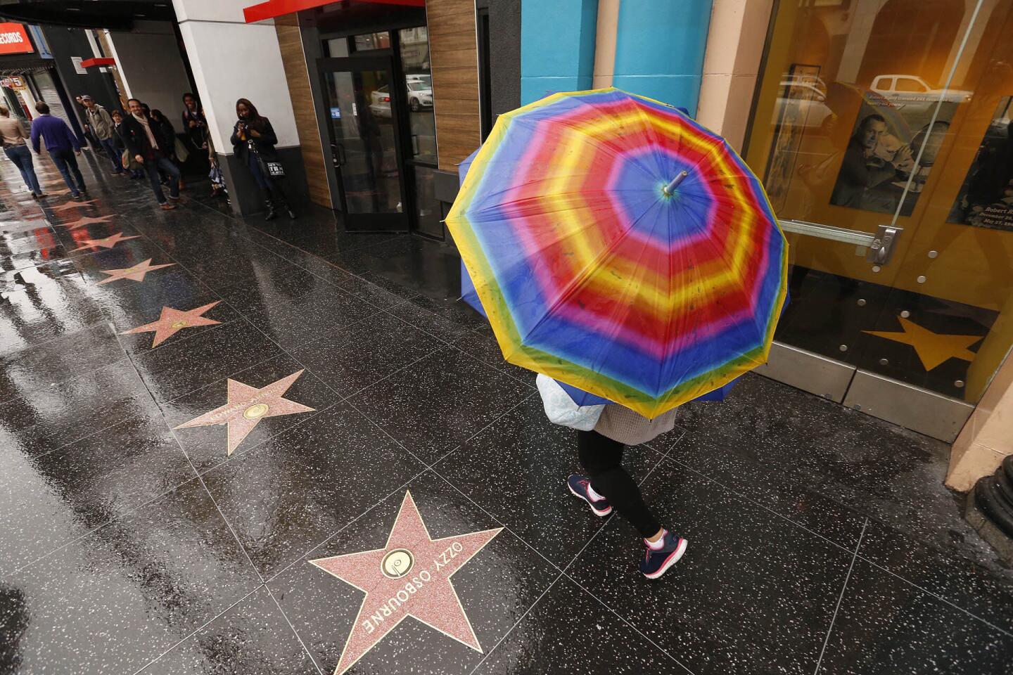 Rainbows on umbrellas are the fashion Thursday morning on the Hollywood walk of fame as a rainstorm moved out of Southern California to make way for warmer conditions.