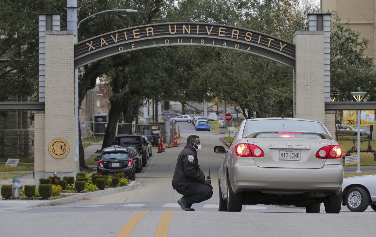 A police officer crouches while speaking to a motorist 