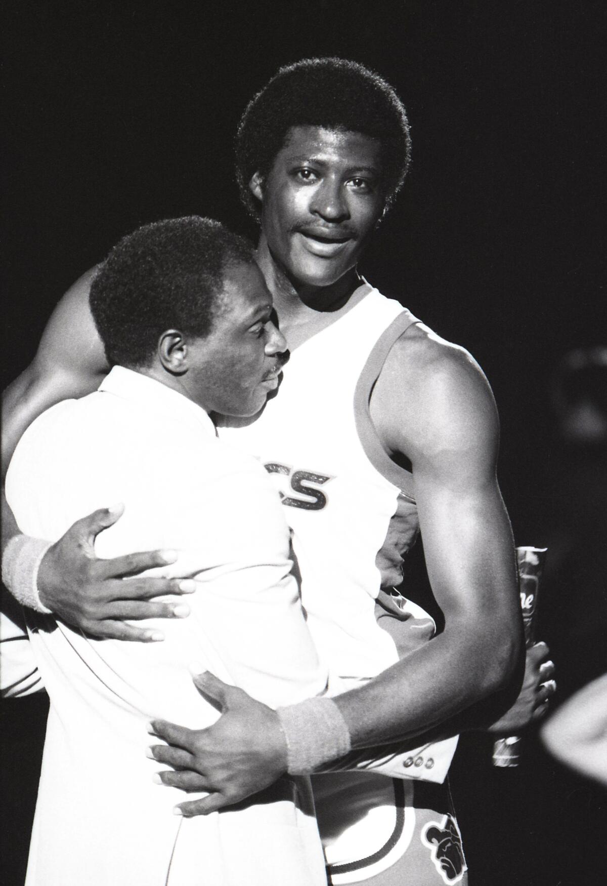 Aztec star Michael Cage gets a farewell hug from Coach Smokey Gaines at the Sports Arena on March 3, 1984.