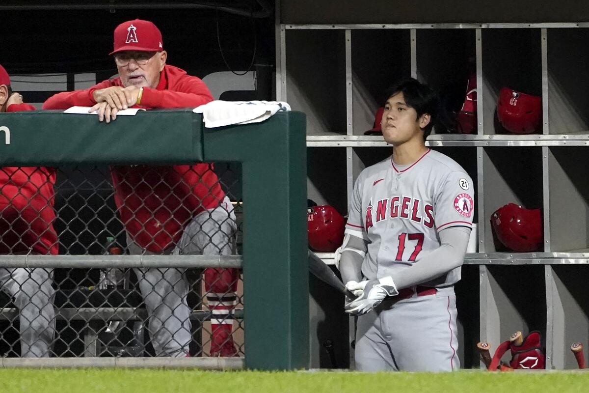 Angels manager Joe Maddon and designated hitter Shohei Ohtani watch from the dugout.