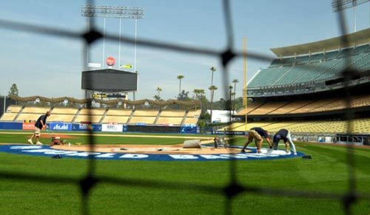 Crew members get Dodger Stadium ready before a game.