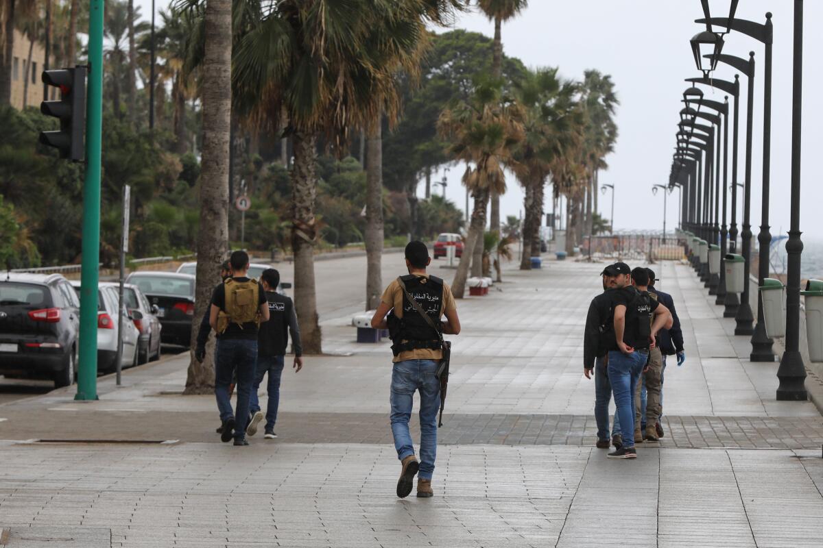 Lebanese intelligence officers patrol a street in Beirut after authorities ordered shops to close for two weeks to fight COVID-19. Lebanon urged people to stay at home for two weeks and prepared to close its main airport to stem a coronavirus outbreak that has killed three people in the country.