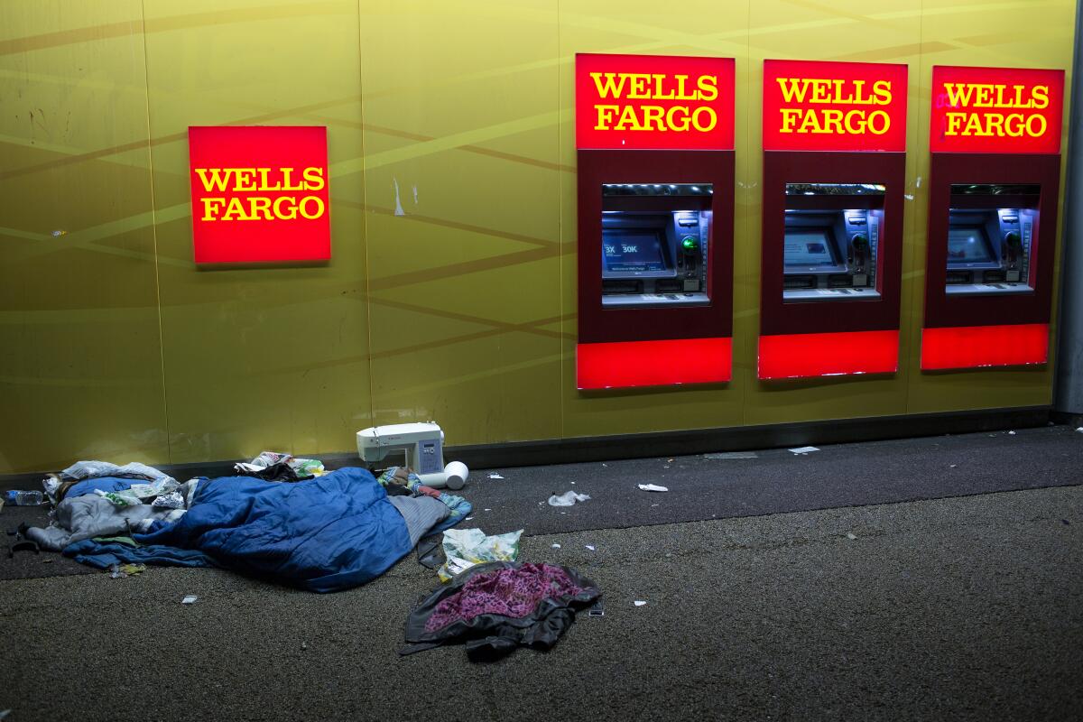 A homeless person's belongings lie on the sidewalk next to a Wells Fargo Bank branch in Los Angeles