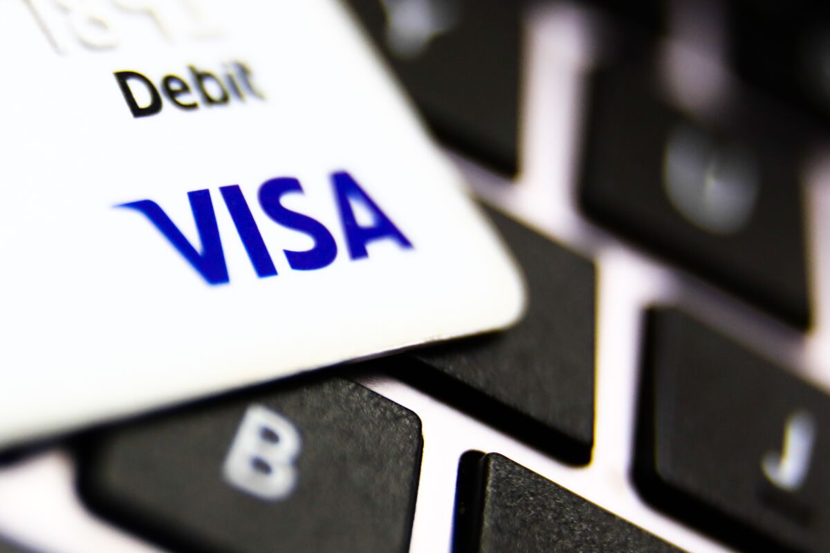 Visa logo on a credit card and a laptop keyboard 