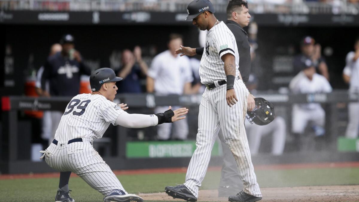 Yankees slugger Aaron Judge, left, and Aaron Hicks celebrate after scoring on a single by Gary Sanchez during the seventh inning Sunday.