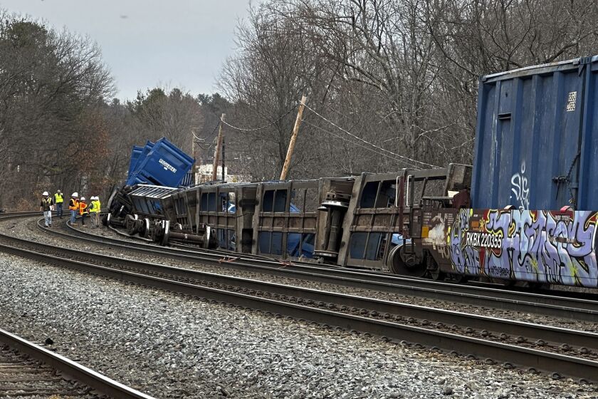 Officials work at the scene of a freight train derailment, Thursday, March 23, 2023, in Ayer, Mass. No hazardous materials were being hauled, according to the local fire department. Video appeared to show Norfolk Southern engines hauling several railcars that had toppled off the tracks onto their sides. (AP Photo/Rodrique Ngowi)