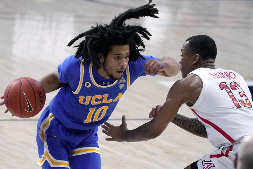 UCLA guard Tyger Campbell (10) drives on Arizona guard James Akinjo during the second half.