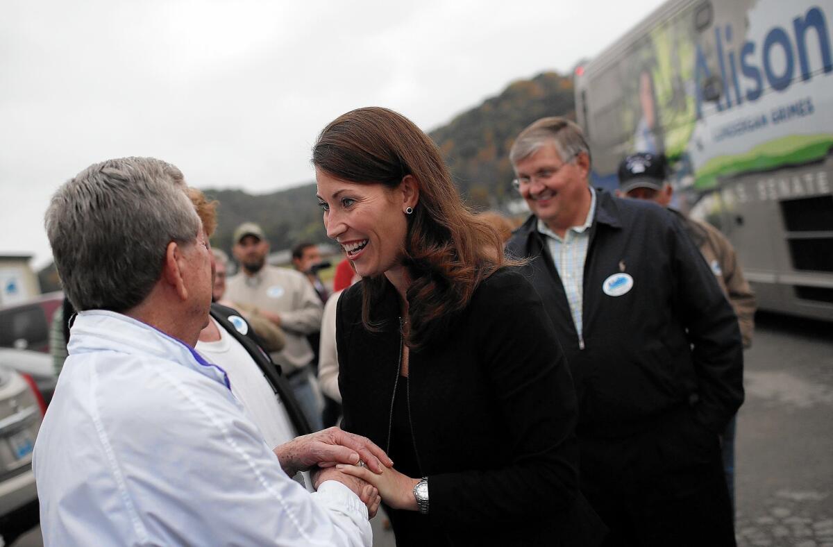 Kentucky Democratic Senate challenger Alison Lundergan Grimes greets supporters at a campaign rally. She has been forced to respond to attack ads linking her with President Obama that have been funded largely by a Kentucky coalition not required to disclose its donors.