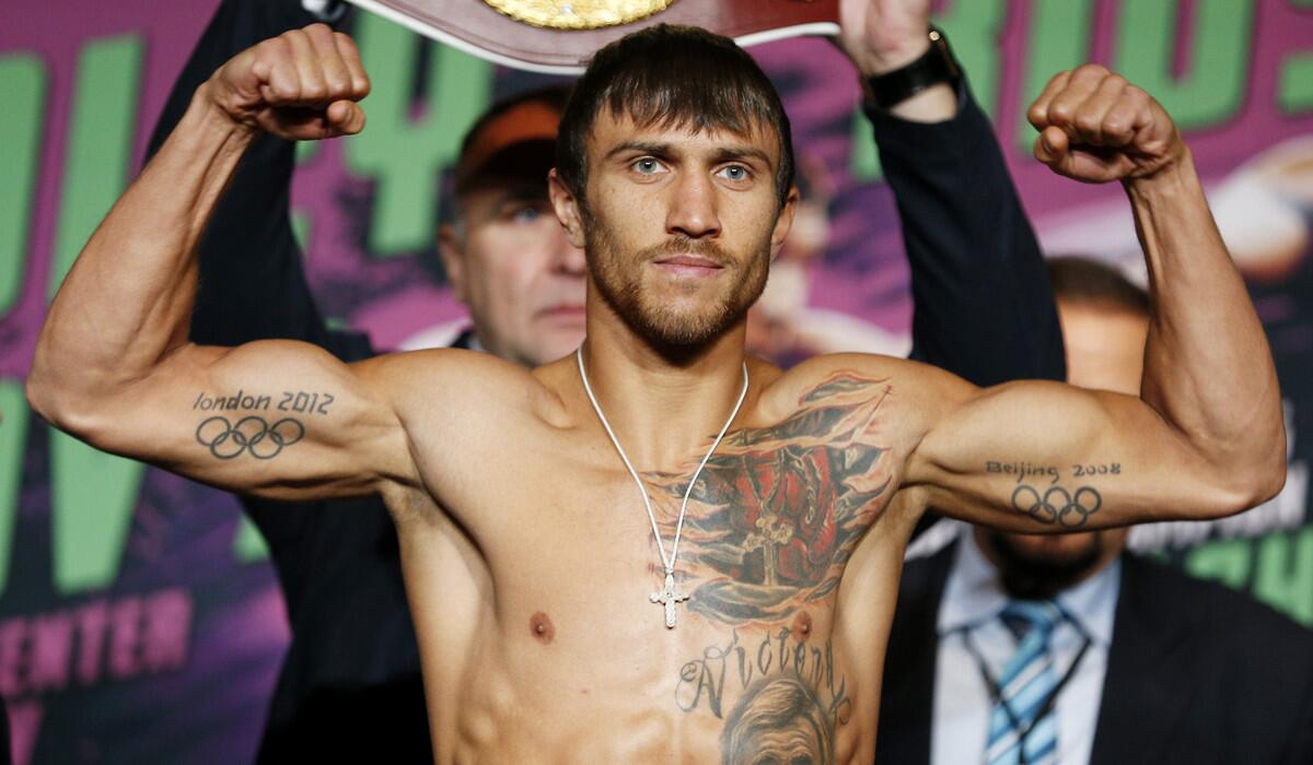 Vasyl Lomachenko poses on the scale during a weigh-in on Friday.