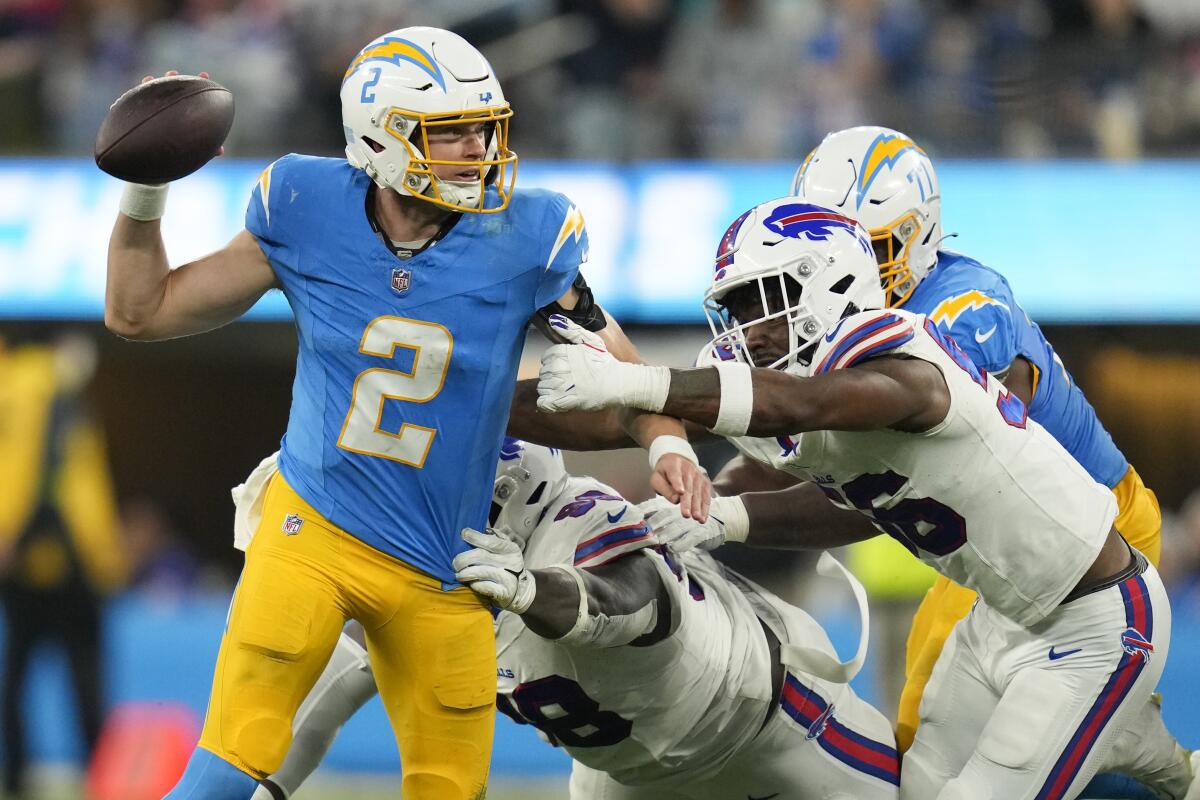 Chargers quarterback Easton Stick is pressured by Bills defensive tackle Poona Ford, center, and defensive end Leonard Floyd.