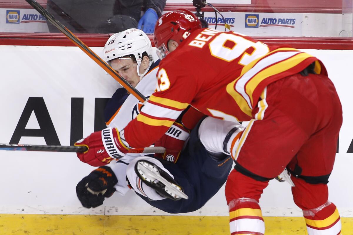 Edmonton Oilers' Josh Archibald, left, takes a hit from Calgary Flames' Sam Bennett during the first period of an NHL hockey game Saturday, April 10, 2021, in Calgary, Alberta. (Larry MacDougal/The Canadian Press via AP)