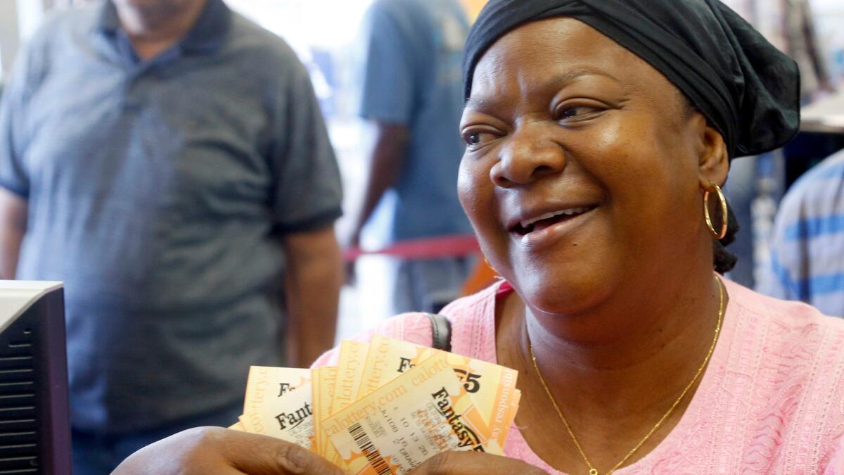 Vee John takes her lottery tickets at Bluebird Liquors in Hawthorne, Calif.