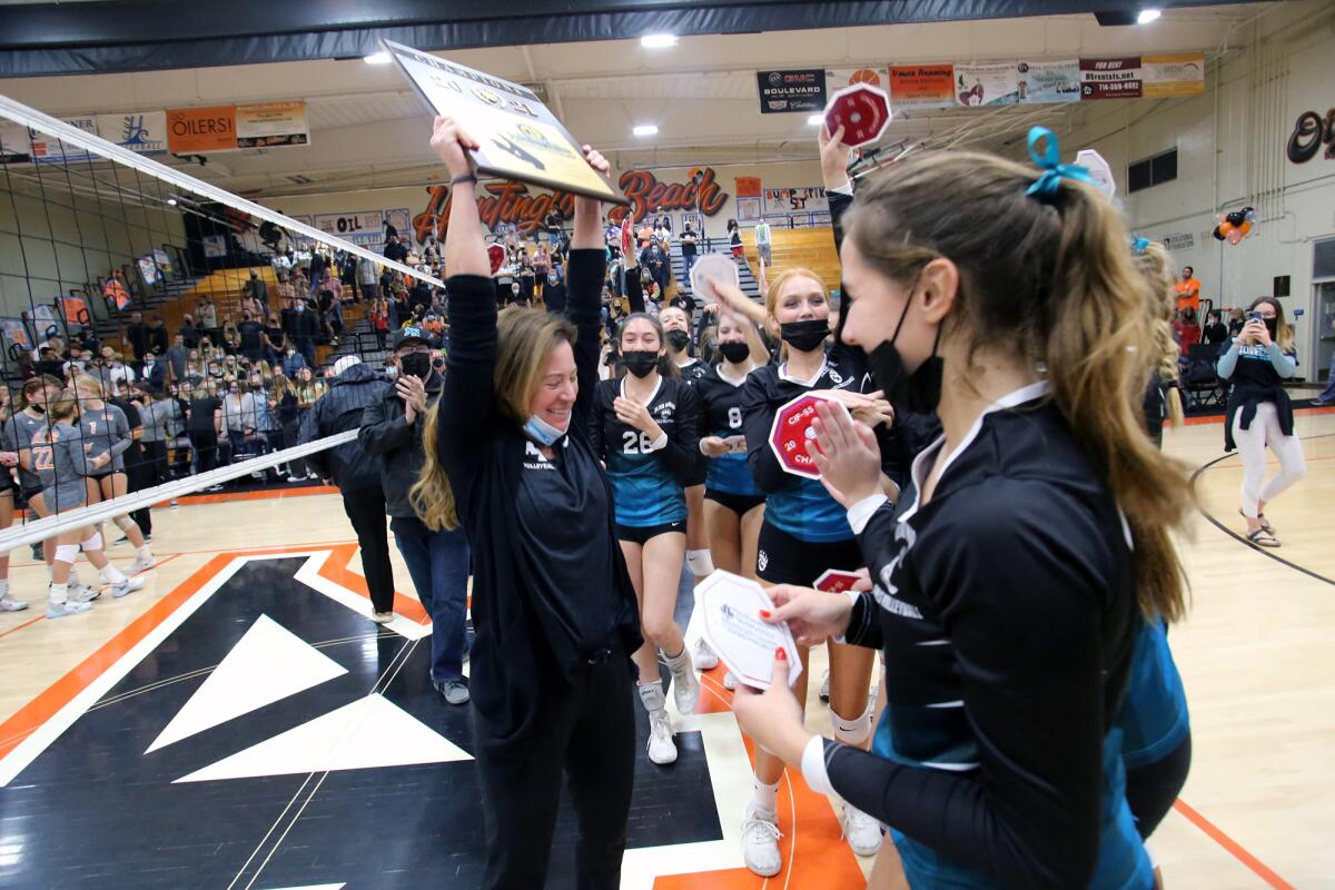 Aliso Niguel girls' volleyball coach Richelle Whiting holds up the CIF Southern Section Division 2 championship plaque.