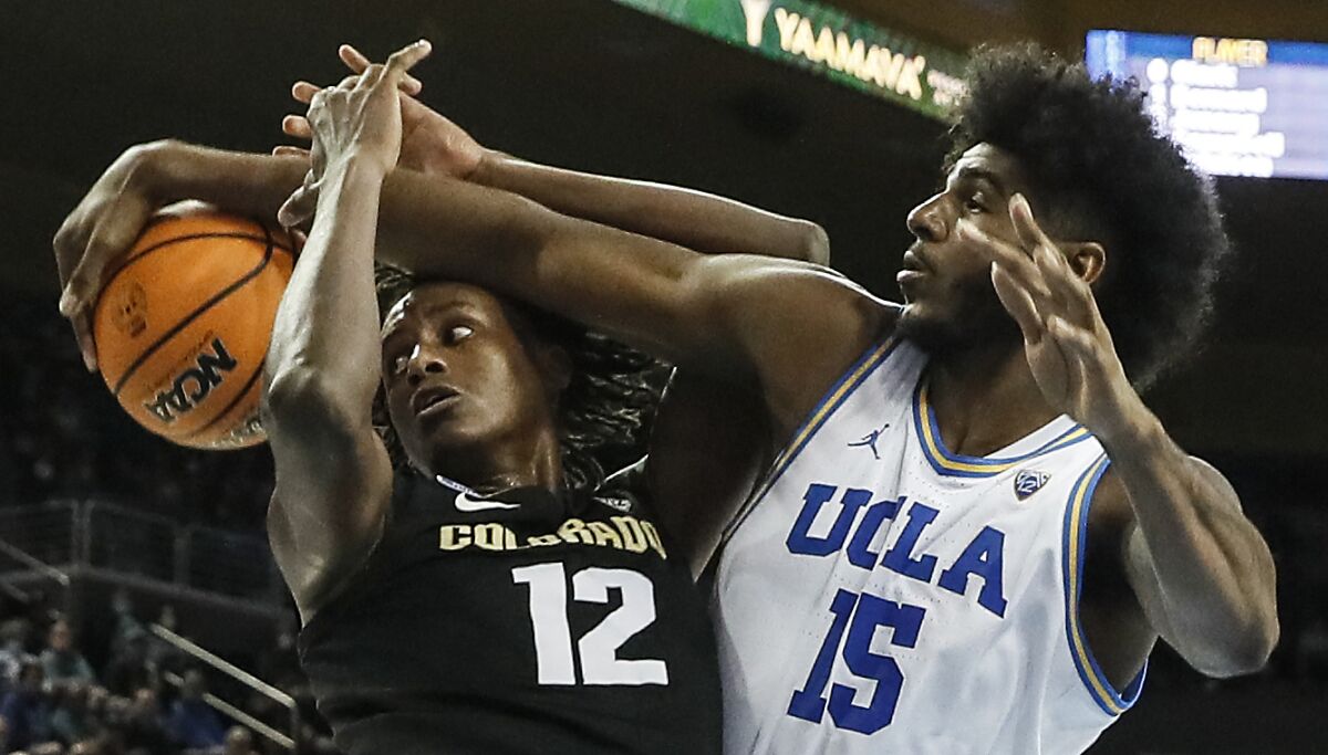 UCLA center Myles Johnson and Colorado Buffaloes forward Jabari Walker try to gain control of the ball.