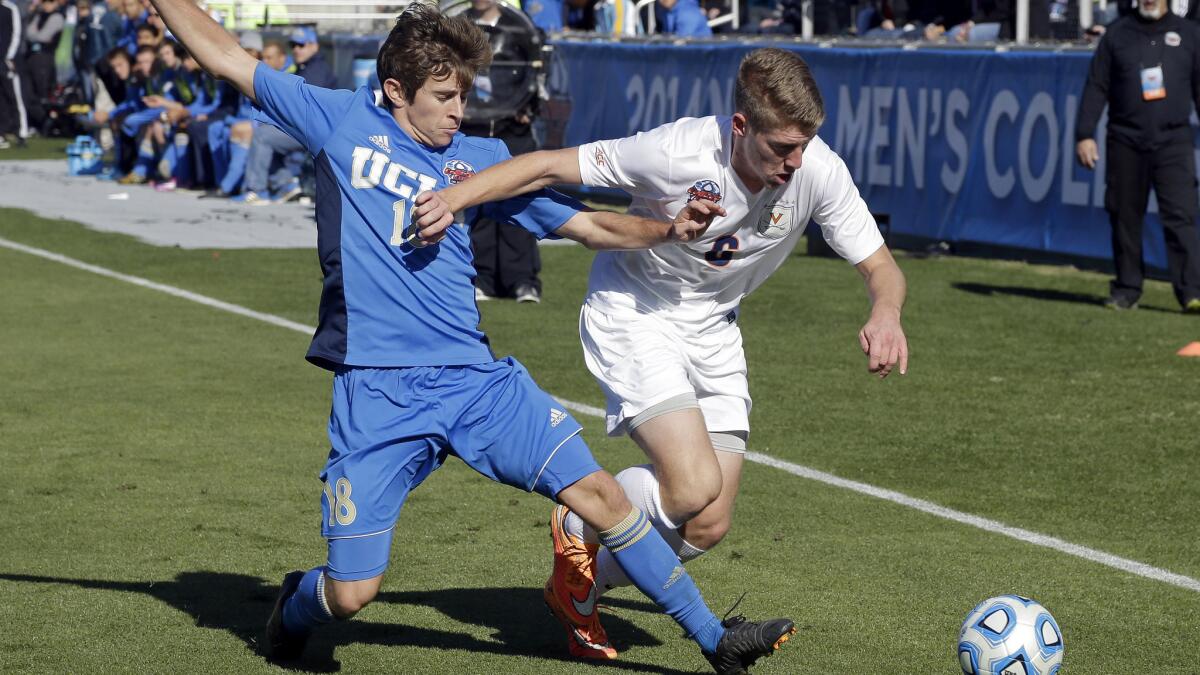 UCLA's Brian Iloski, left, and Virginia's Scott Thomsen chase after the ball during UCLA's loss on penalty kicks in the NCAA championship game Sunday.