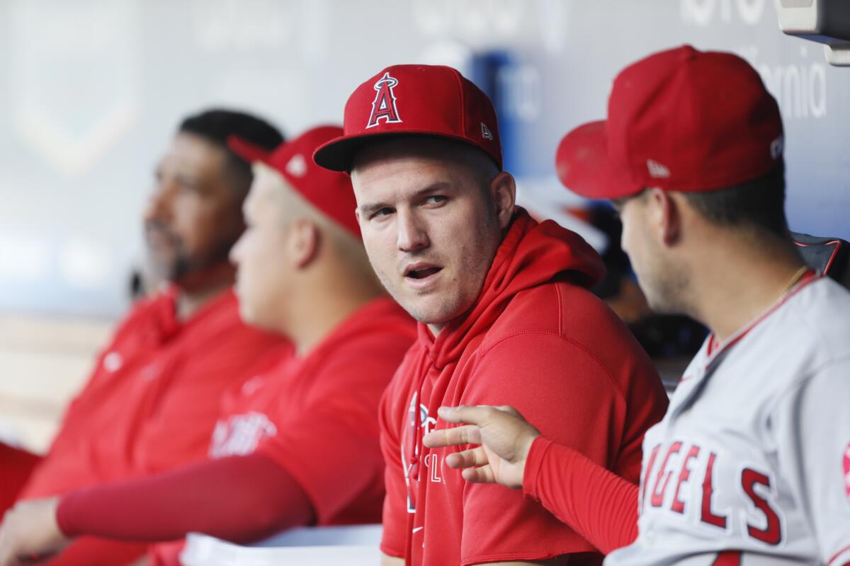 Angels outfielder Mike Trout, center, talks with shortstop Jose Iglesias in the dugout
