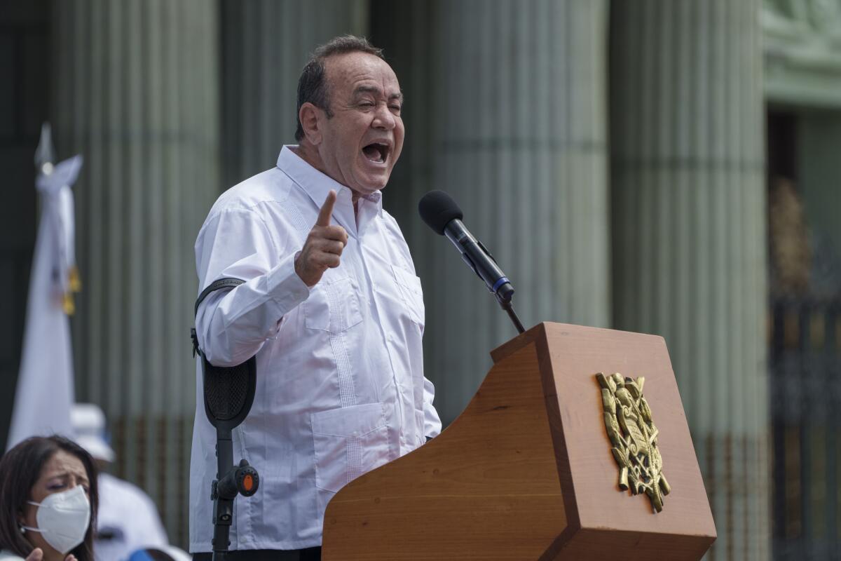 Guatemalan President Alejandro Giammattei speaks at a podium
