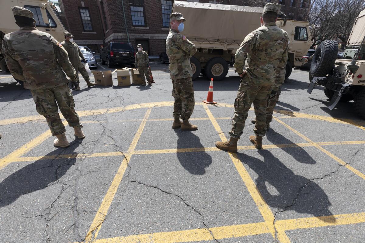 FILE — Massachusetts National Guard soldiers help with logistics in this Friday, April 17, 2020 file photo, at a food distribution site outside City Hall, in Chelsea, Mass. Mass. Gov. Charlie Baker on Monday, Sept. 13, 2021, activated the state's National Guard to help with busing students to school as districts across the country struggle to hire enough drivers. (AP Photo/Michael Dwyer, File)