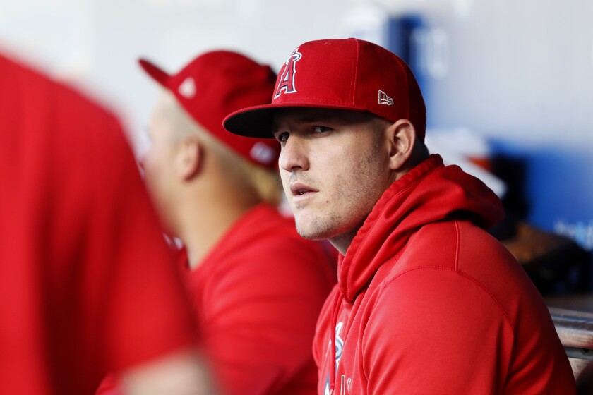 Los Angeles Angels' Mike Trout looks over from the dugout before a baseball game.