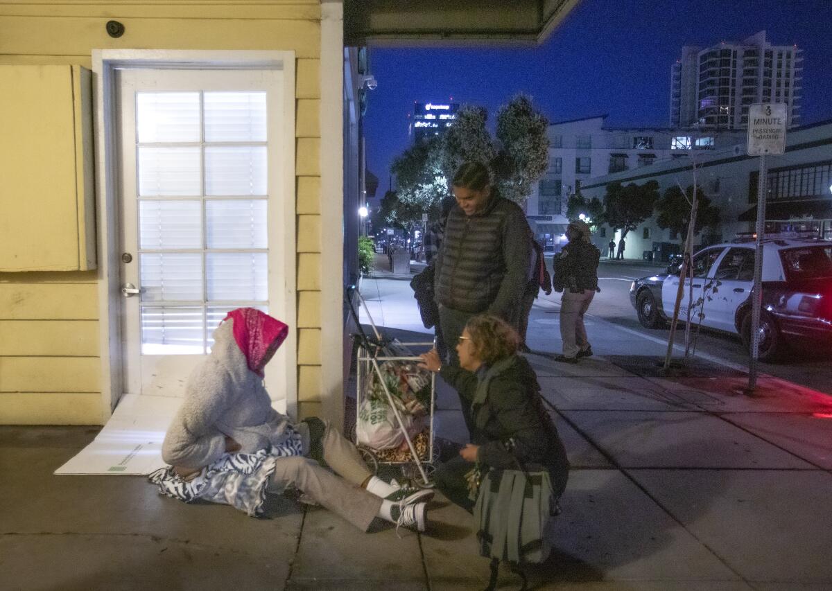Antoinette Fallon and Appaswamy "Vino" Pajanor of Catholic Charities speak with a homeless woman in San Diego.