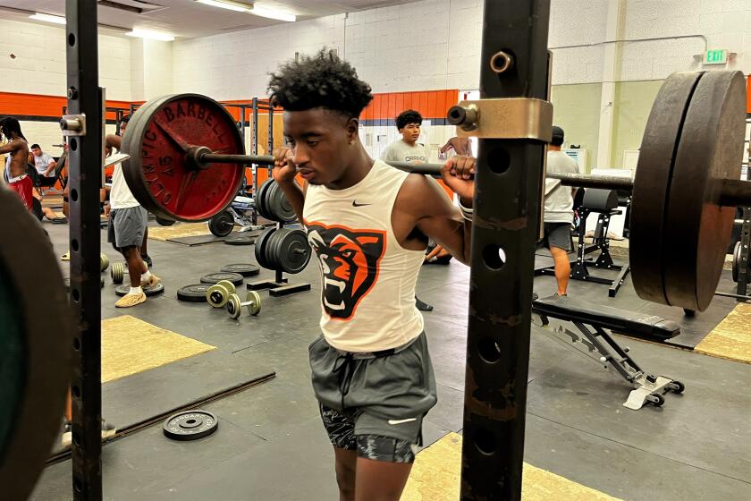 Orange High running back Kobe Boykin get set to squat weights during a workout on Aug. 1.
