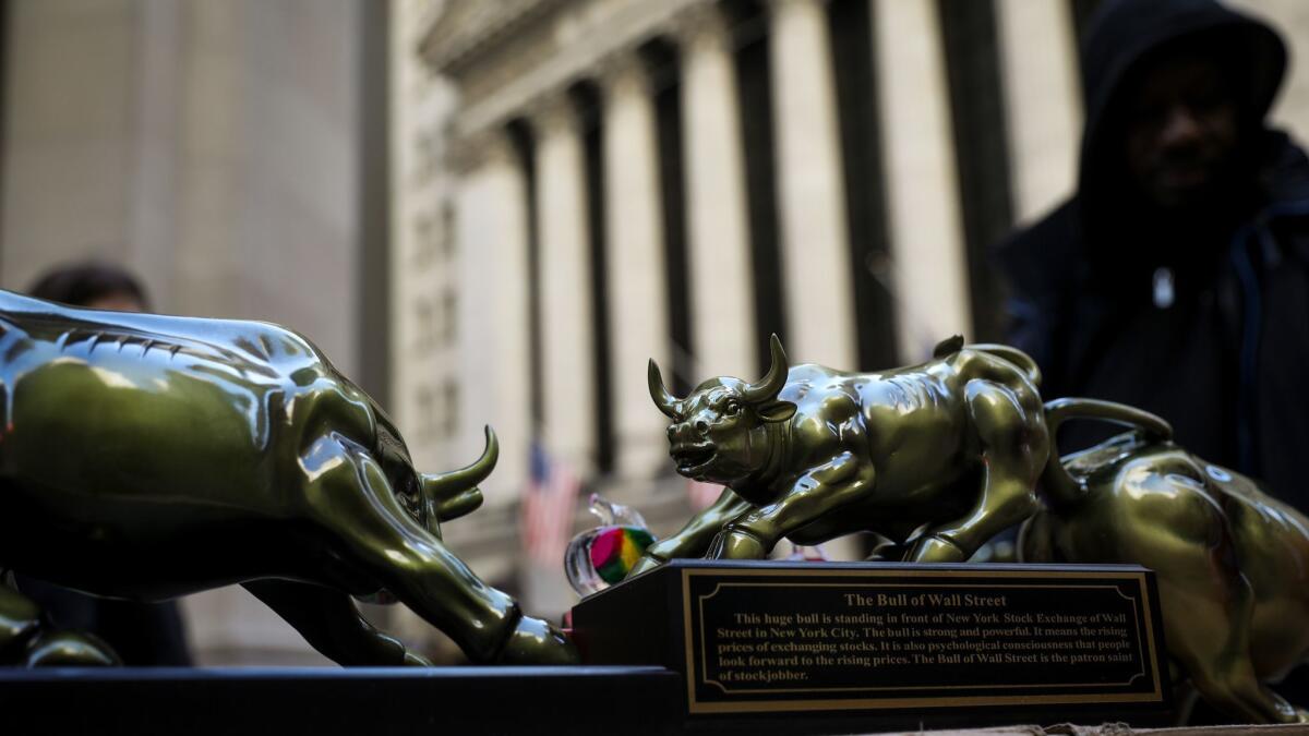 A street vendor sells replicas of the Wall Street Bull statue outside the New York Stock Exchange on March 26.