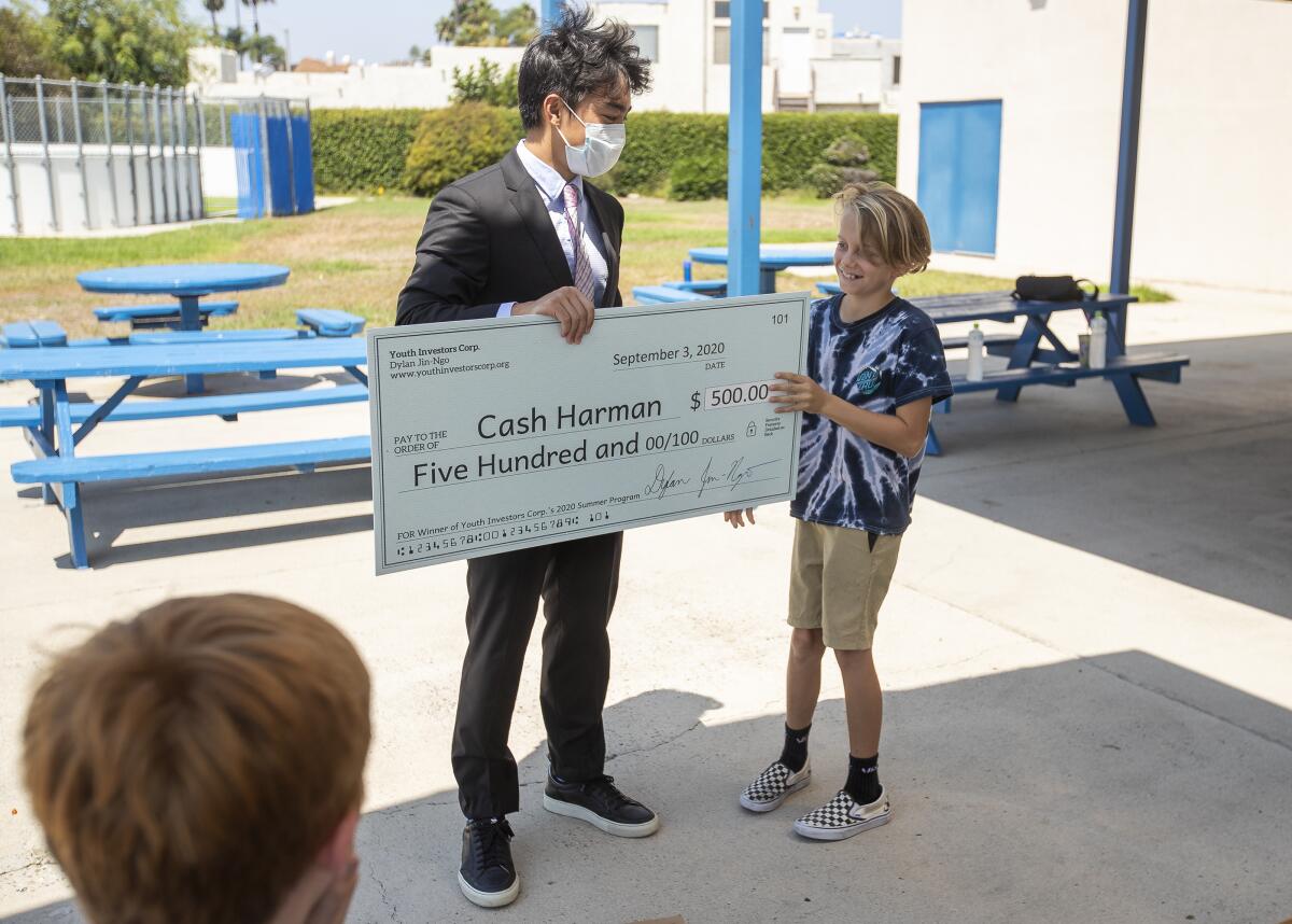 Dylan Jin-Ngo presents a check for $500 to Cash Harman at the Boys & Girls Clubs of Huntington Valley.