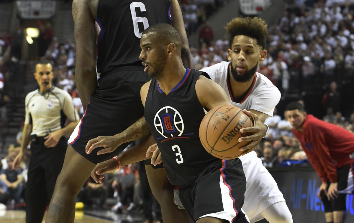 Clippers guard Chris Paul (3) dribbles around a pick as Trail Blazers guard Allen Crabbe (23) gives chase in the first quarter of Game 4.