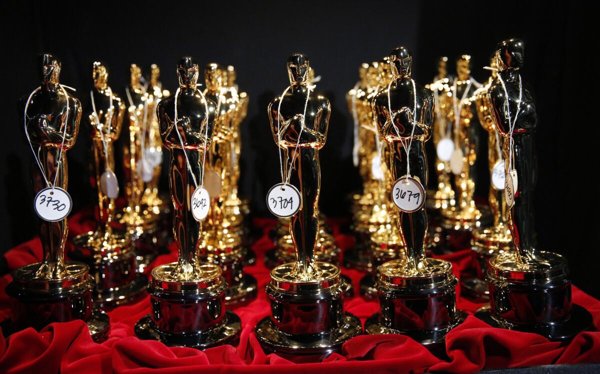 Oscars statuettes with tags positioned on a red tablecloth