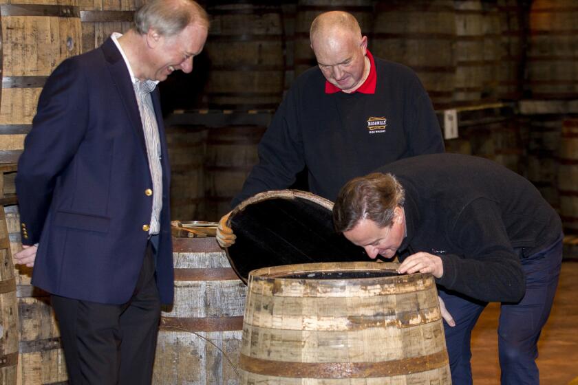 British Prime Minister David Cameron smells a whiskey barrel during a visit to the Bushmills distillery in Northern Ireland on Feb. 27.