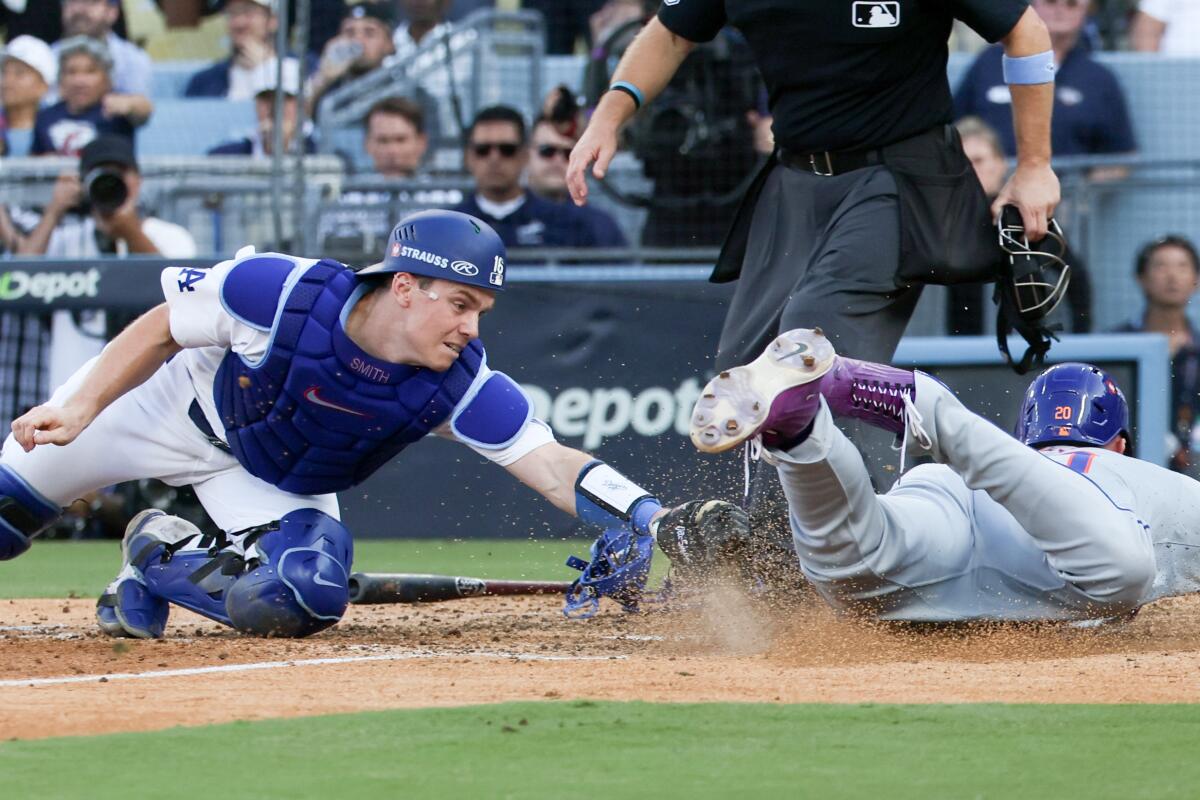 Dodgers catcher Will Smith, left, tries to tag out Mets baserunner Pete Alonso in Game 2 of the NLCS on Oct. 14.