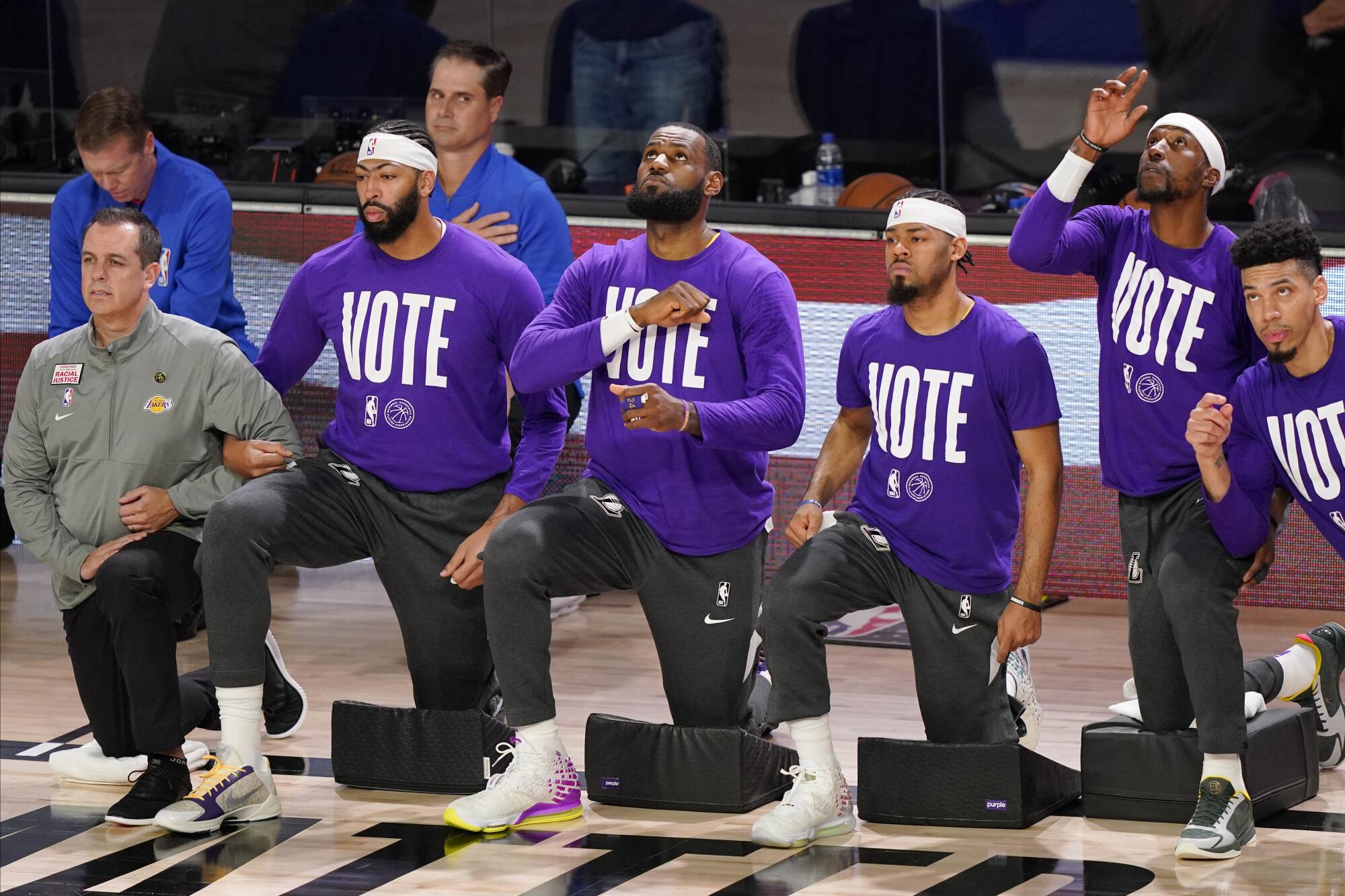 Members of the Lakers, including LeBron James, third from left, kneel before a playoff game 