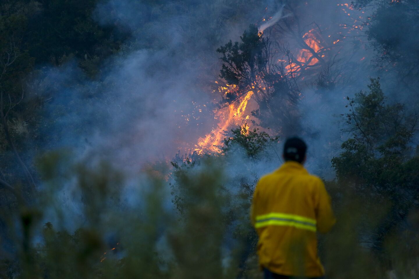 Firefighters keep an eye on the flames on a hillside in Duarte as the fast-moving Fish fire continues to burn Tuesday morning.
